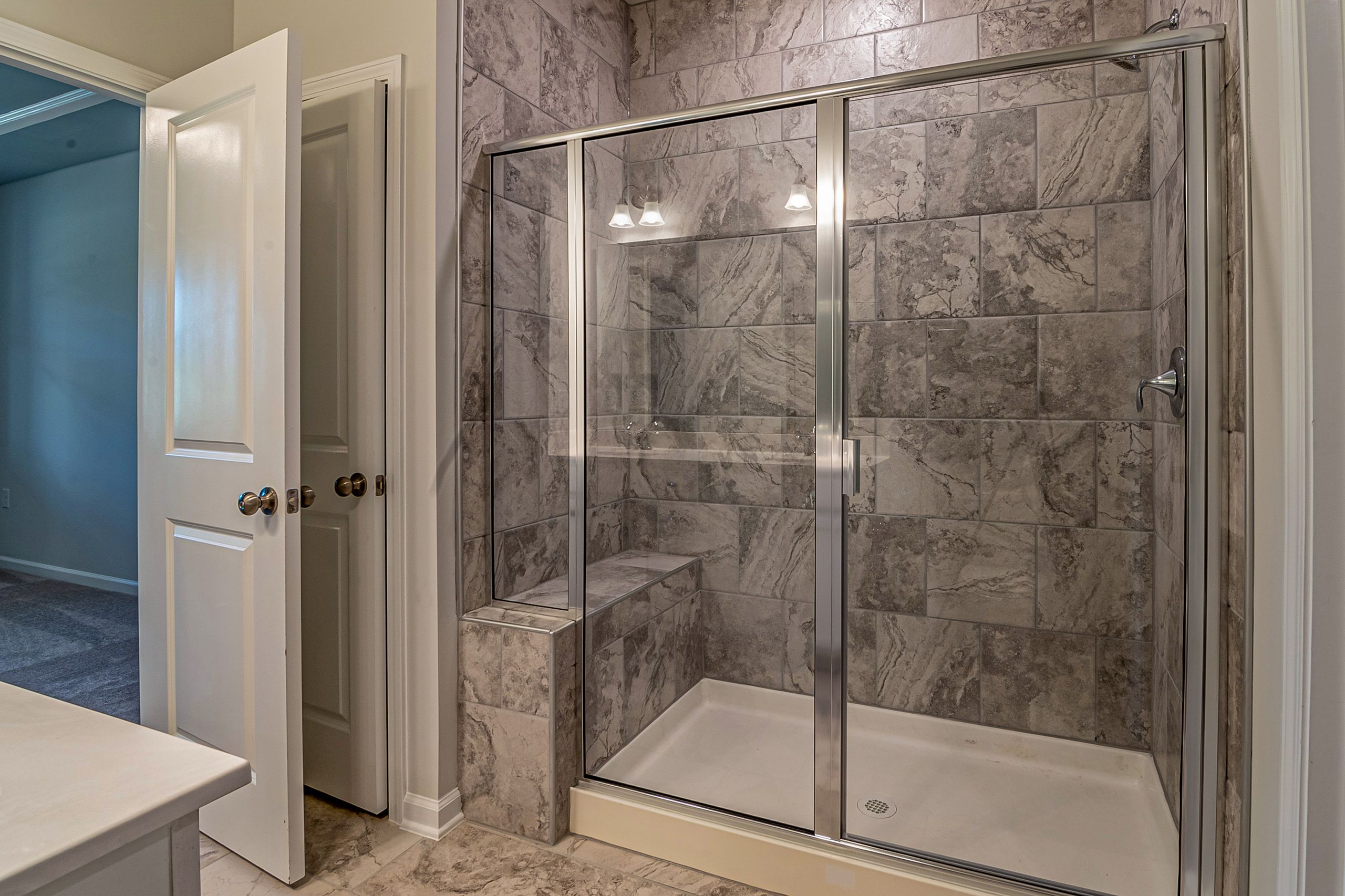 Glass shower doors installed in a modern luxury bathroom.